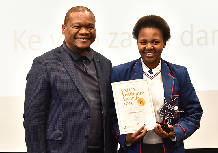 MEC for Education, Dr Tate Makgoe, presents an award to Khesa Maphakiso from Beacon High School at the ceremony.