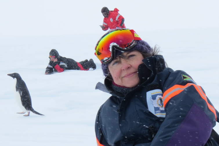 Prof Linda Basson recently returned from a three-month research expedition in Antarctica. Here she is, relaxing on the ice with the ever-inquisitive Adelie penguins having a gander at these strangers in their snowy world.